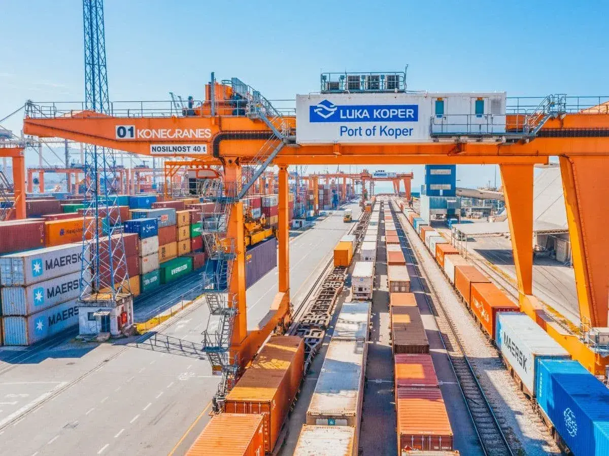 Ein geschäftiger Hafen mit Kränen, Containern und Zügen. Die "Luka Koper Port of Koper" ist bereit für den nächsten telex release.