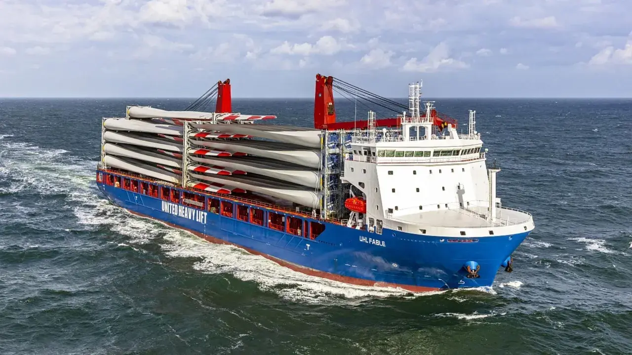 Ein **heavy lift vessel** transportiert viele Rotorblätter für Windkraftanlagen über das Meer.