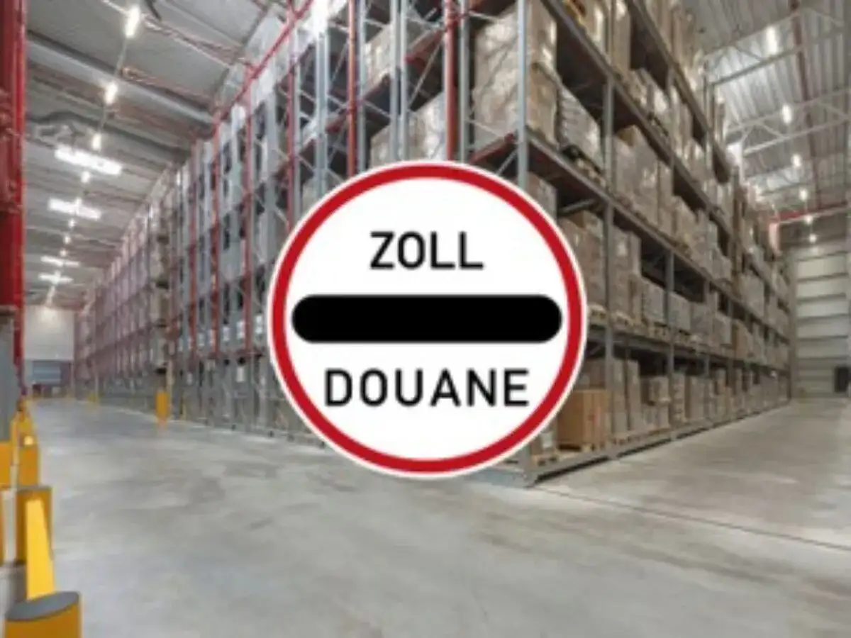 Großes Lager mit hohen Regalen voller Waren. Ein Schild mit "ZOLL DOUANE" weist auf einen bonded store hin.