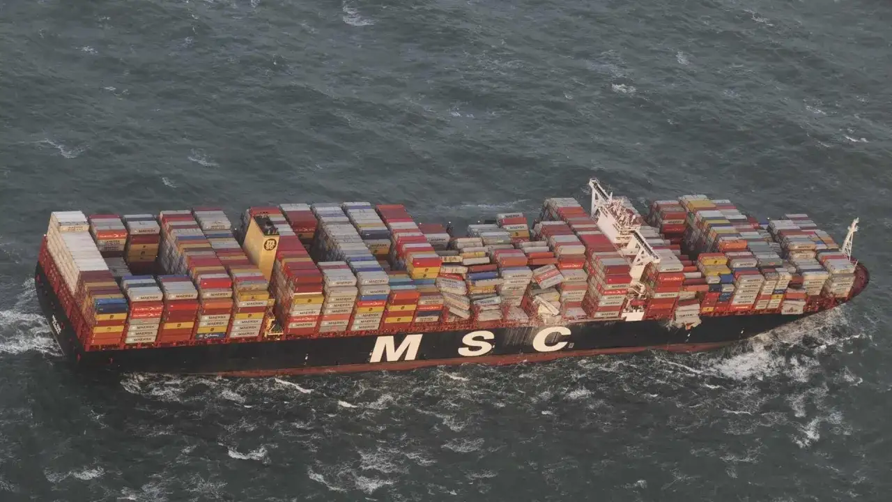 Ein riesiges Containerschiff der MSC f&auml;hrt durch raue See. Die Ladung, ein allgemeiner Durchschnitt von Waren, ist hoch gestapelt.