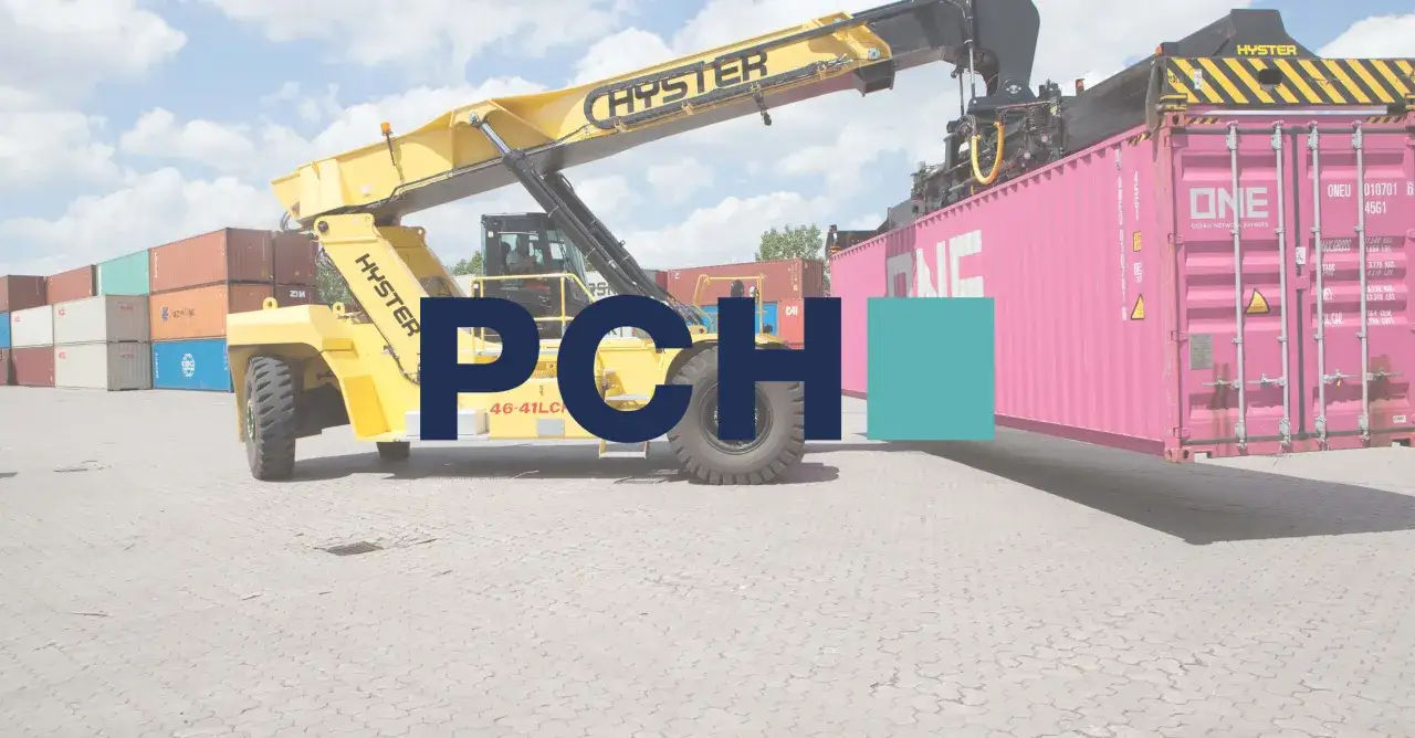 Ein gelber Containerstapler hebt einen rosa Container auf einem container freight station.