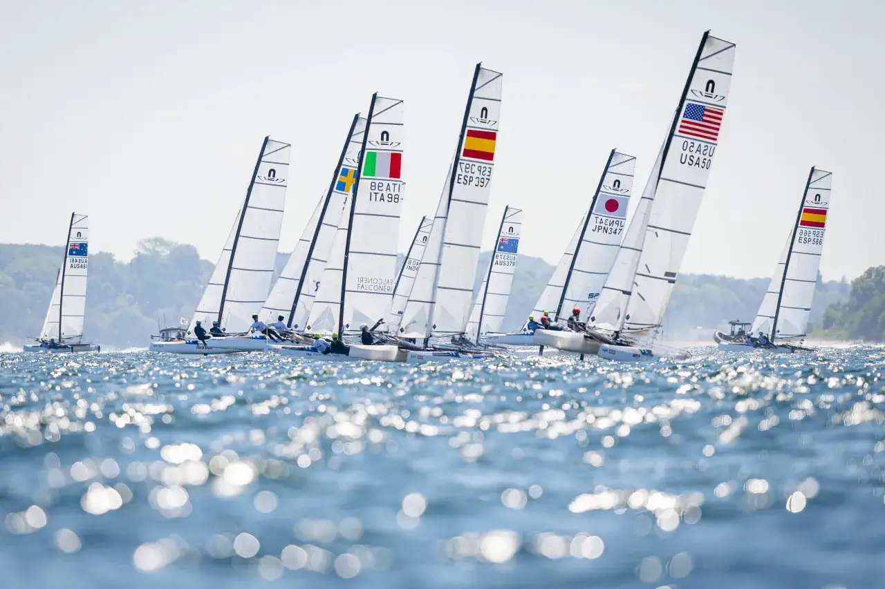 Segelboote mit Nationalflaggen, darunter USA und Italien, bei der WM Kiel.