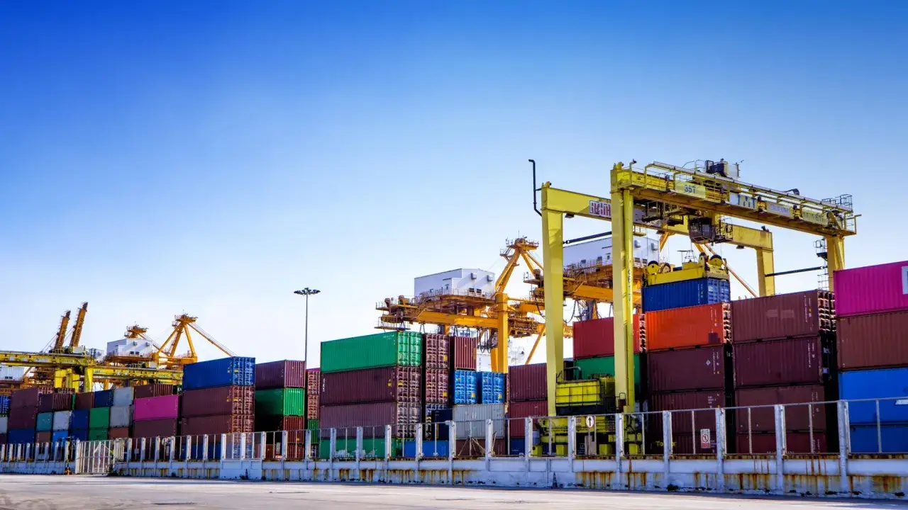 Containerhafen mit Kr&auml;nen und vielen Frachtcontainern. Wichtiger Umschlagplatz f&uuml;r den globalen Handel, abgesichert durch marine insurance.