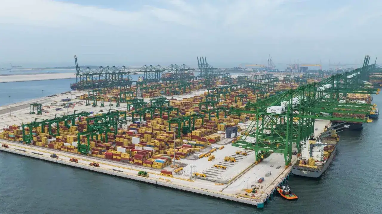 Der riesige Containerhafen in Singapur, ein Labyrinth aus roten und gelben Frachtcontainern, wird von zahlreichen gr&uuml;nen Portalkr&auml;nen dominiert.