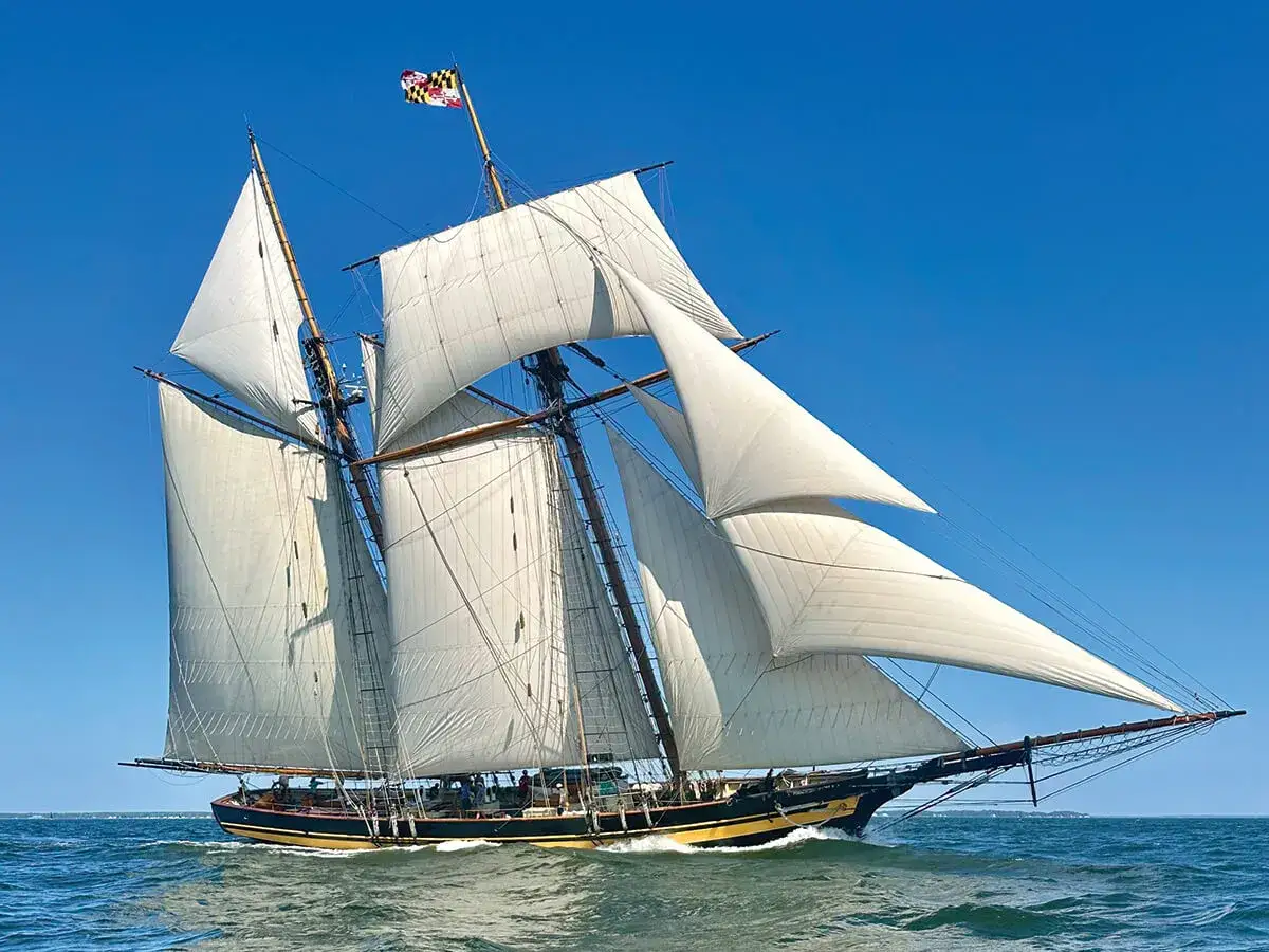Ein majest&auml;tischer clipper ship segelt unter vollen wei&szlig;en Segeln auf blauem Meer.