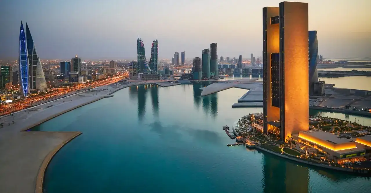 Moderne Skyline am Bahrain Port bei D&auml;mmerung. T&uuml;rme spiegeln sich im ruhigen Wasser.