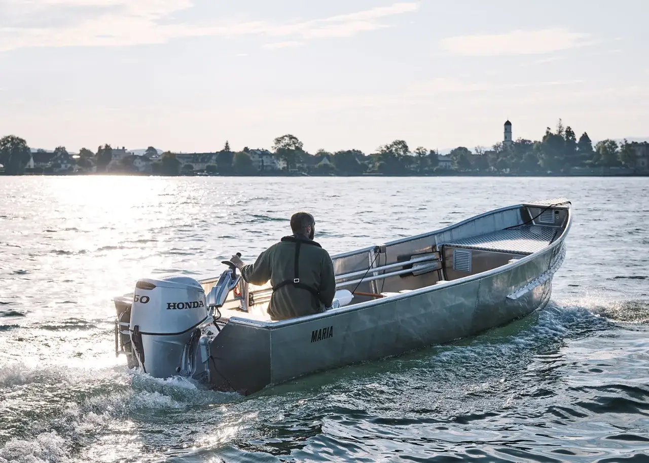 Mann steuert ein Angelboot namens 