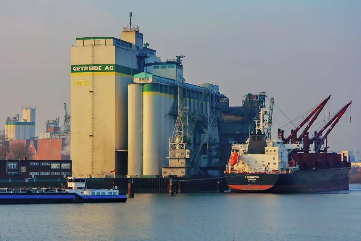Getreidespeicher AG am Hafen. Ein Schiff wird beladen, was das Cross-Docking-Prinzip veranschaulicht: Ware direkt vom Schiff in den Weitertransport.