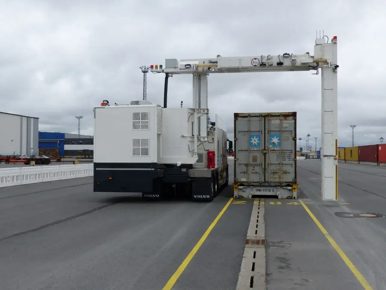 LKW mit Container unter einem Röntgenscanner. Die Zollabfertigung ist im Gange.