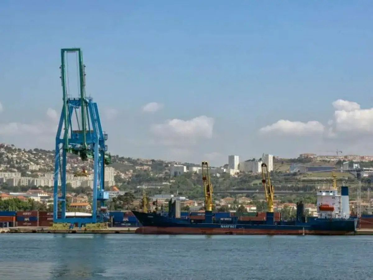Ein gro&szlig;er Hafenkran bel&auml;dt ein Frachtschiff in einem der gr&ouml;&szlig;ten H&auml;fen Europas.