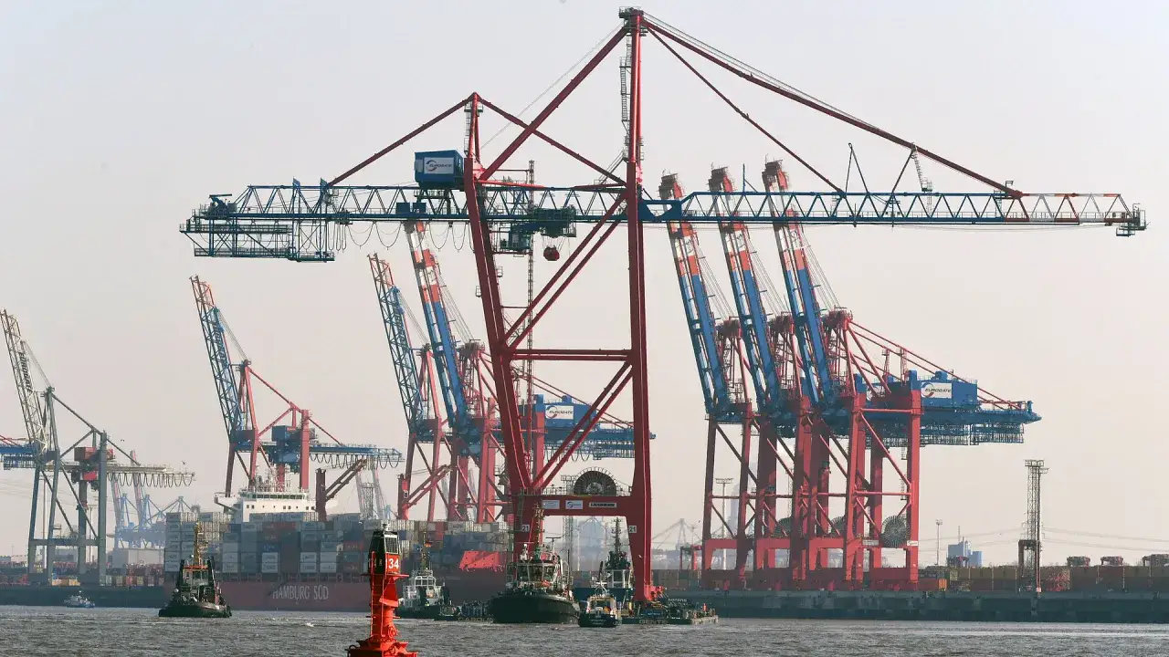 Gro&szlig;e Hafenkr&auml;ne laden einen Containerschiff. Die Kosten f&uuml;r den terminal handling charge sind hier sichtbar.