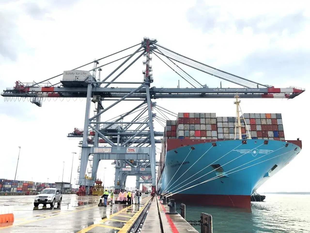 Großes Containerschiff liegt im Vung Tau Port, beladen mit Fracht unter riesigen Kränen.
