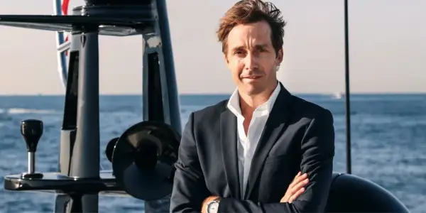 Martin Hager, mit verschränkten Armen auf einem Boot, blickt zuversichtlich in die Kamera.
