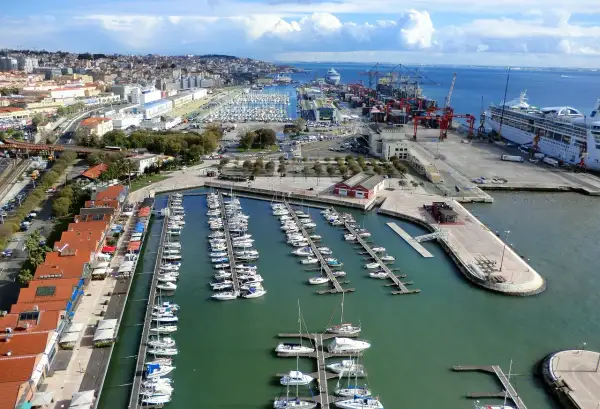 Blick auf den geschäftigen Lissabon Port mit vielen Segelbooten und einem Kreuzfahrtschiff.