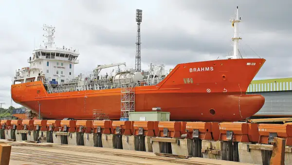 Orange product tanker "BRAHMS" in dry dock, ready for maintenance.